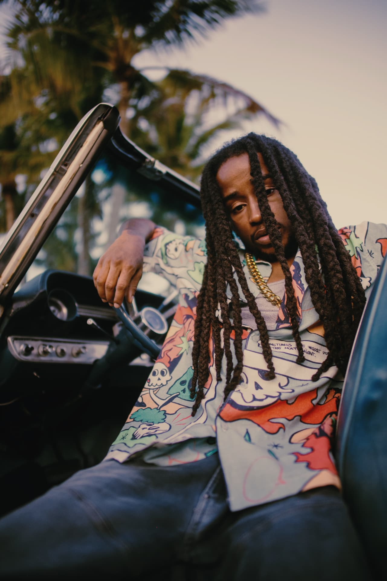 Portrait of KJ Skippa Mak Marley in a vintage convertible under palm trees